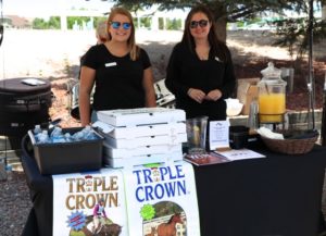 two women standing at Triple Crown booth